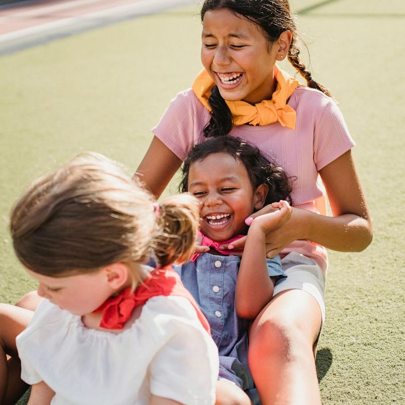 Group of diverse children playing and laughing together in a bright room.